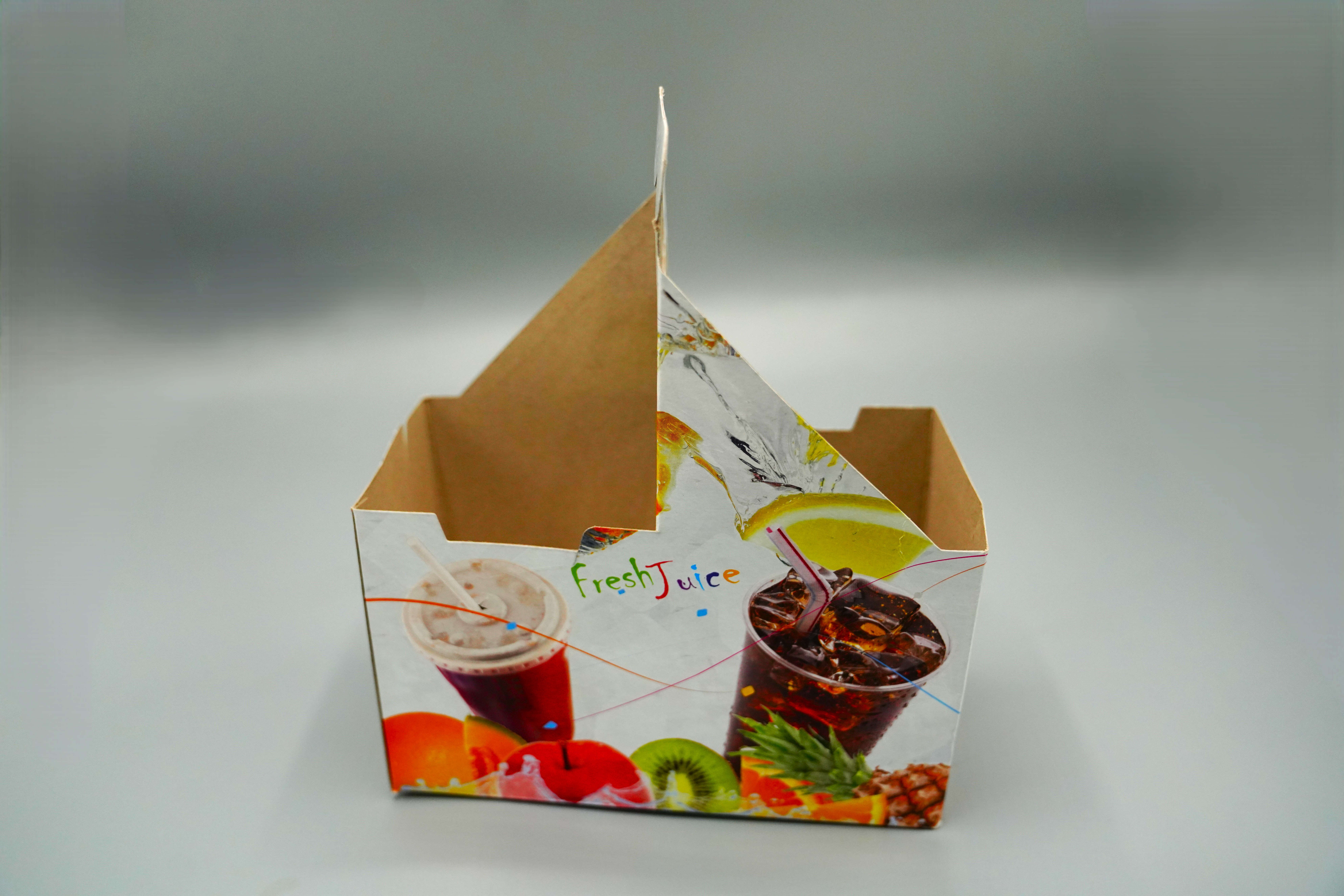 A Rectangular Cardboard Juice cup holder that holds two cups, measuring 19 x 9 cm, with a handle for easy carrying. The carton contains 5Set.